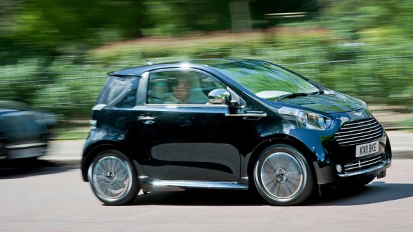 Когато Йън Колъм създаде модерния вид на Aston - с елегантната, заоблена трапецоидна решетка и семплите овални светлини - той го бе предвидил за употреба в елегантни, издължени спортни купета. Представете си ефекта, когато това изящно лице бе пришито насила на муцунката на малката Toyota IQ. Просто за да успее Aston Martin да излъже някак европейските чиновнически изисквания за средни емисии от цялата гама. Още по-излъгани от чиновниците останаха онези шепа хорица, които навремето склониха да платят по 50,000 лири за ребрандирана Toyota, която в оригиналния си вид струваше пет пъти по-малко - и изглеждаше по-добре. 
